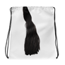 Vit gympapåse med svart hästsvans och svarta remmar.