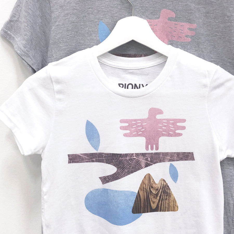 Närbilder av vita och grå T-shirts med motivet "Mountain" i rosa/blå/beige färger