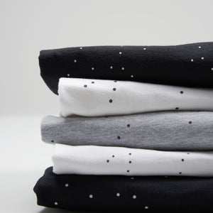 Mönstret Correlations är små svarta eller vita prickar på vit, svart eller ljusgrå T-shirt. 